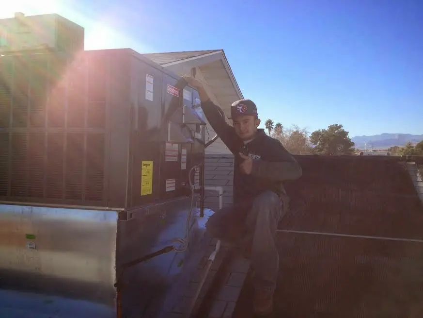 HVAC technician performing HVAC Inspection on a rooftop unit in Broadlands